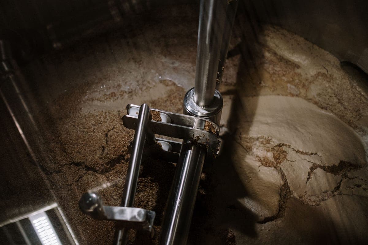 Steam rising from a brewing kettle with a thermometer